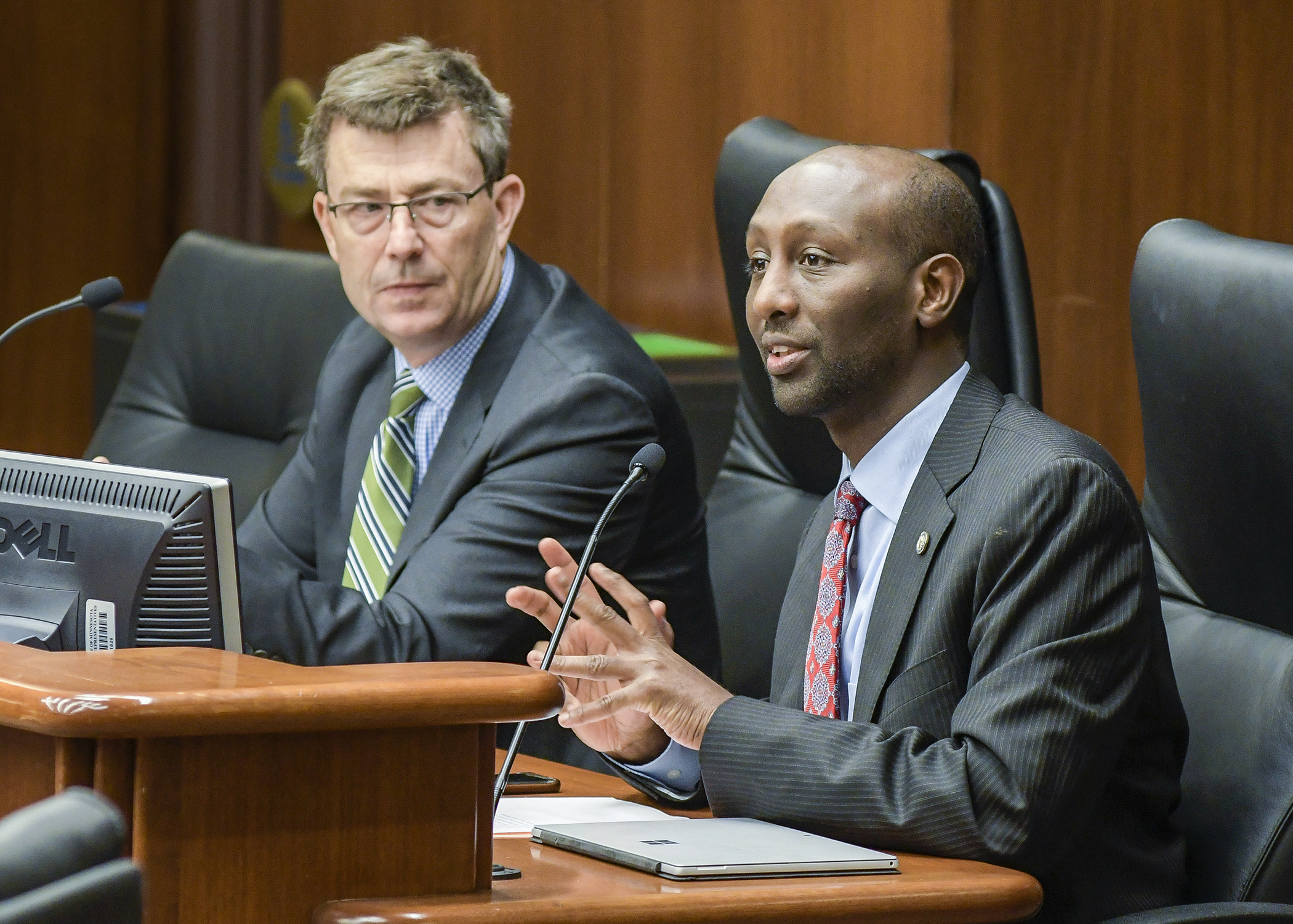 Hennepin County Commissioner Mike Opat listens as Rep. Mohamud Noor testifies before the House Health and Human Services Finance Division on a bill that would provide funding for foster families recruitment in Hennepin County. Photo by Andrew VonBank